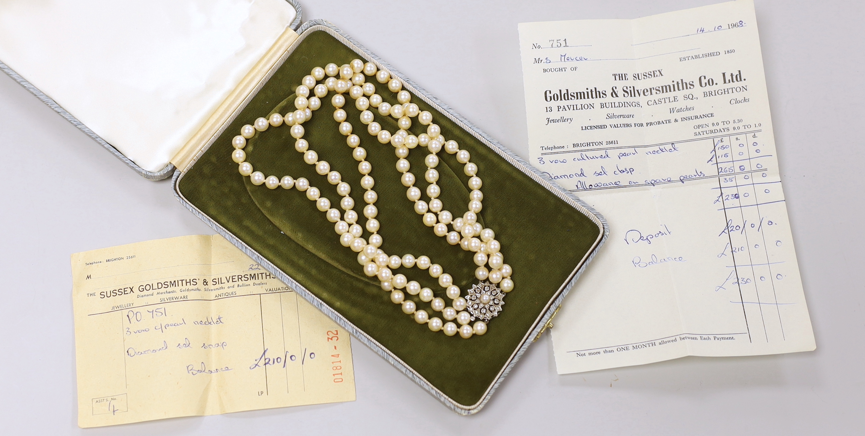 A 1960's triple strand cultured pearl choker necklace, with diamond and cultured pearl cluster set white metal clasp, 40cm, with box and 1968 original purchase receipt.